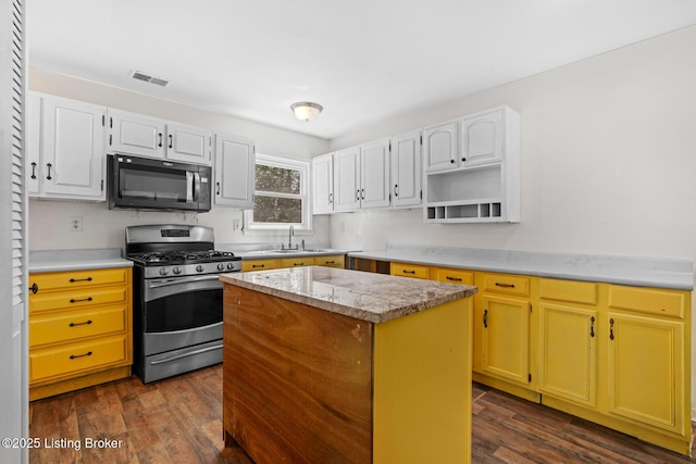 823 S Jackson St, Louisville, KY 40203 - kitchen with black microwave, stainless steel gas range oven, a sink, dark wood-style floors, and a center island