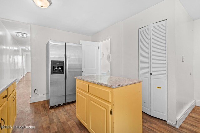 823 S Jackson St, Louisville, KY 40203 - kitchen with stainless steel fridge, dark wood-style flooring, a kitchen island, baseboards, and light stone counters