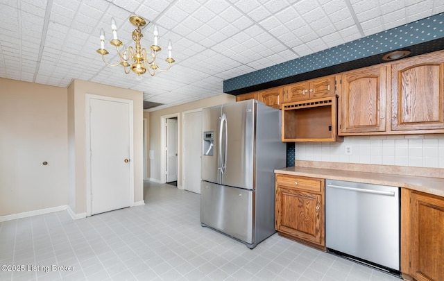 7212 Peppermill Ct, Louisville, KY 40228 - kitchen featuring stainless steel appliances, a chandelier, light countertops, and brown cabinetry
