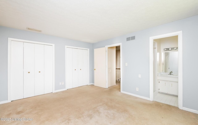 7212 Peppermill Ct, Louisville, KY 40228 - unfurnished bedroom featuring two closets, light colored carpet, baseboards, a sink, and ensuite bathroom