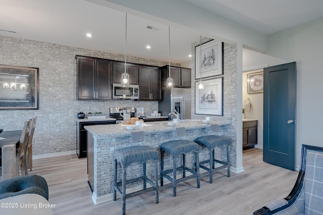 101 Exploration Unit 61A, Shelbyville, KY 40065 - kitchen featuring appliances with stainless steel finishes, a breakfast bar, dark brown cabinetry, and light wood-style flooring