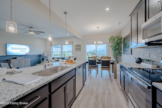 101 Exploration Unit 61A, Shelbyville, KY 40065 - kitchen featuring appliances with stainless steel finishes, a sink, a chandelier, light stone countertops, and tasteful backsplash