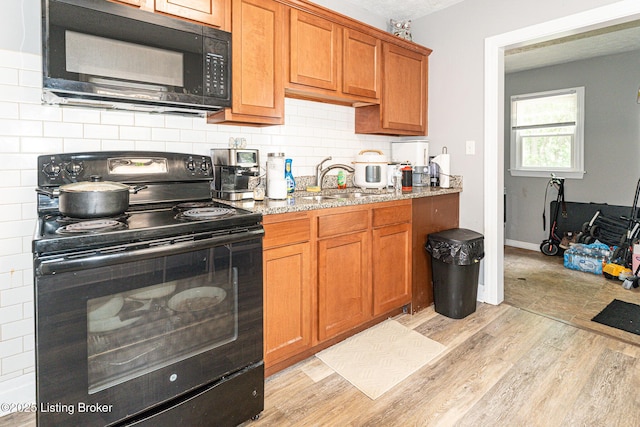 1225 Bicknell Ave, Louisville, KY 40215 - kitchen featuring black appliances, brown cabinetry, decorative backsplash, light stone counters, and light wood finished floors