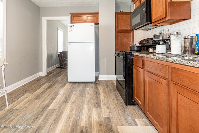 1225 Bicknell Ave, Louisville, KY 40215 - kitchen with black appliances, brown cabinetry, light wood-style floors, and a textured ceiling