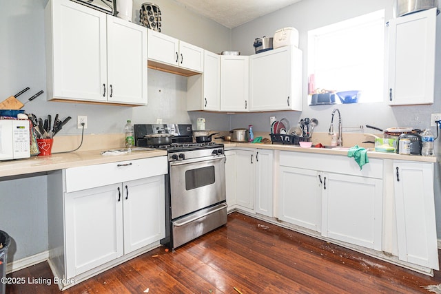 1407 Bluegrass Ave, Louisville, KY 40215 - kitchen with stainless steel range with gas cooktop, light countertops, a sink, white cabinetry, and white microwave
