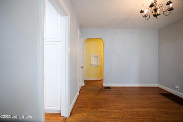 3521 Warner Ave, Louisville, KY 40207 - empty room with arched walkways, a chandelier, baseboards, and light wood-style flooring