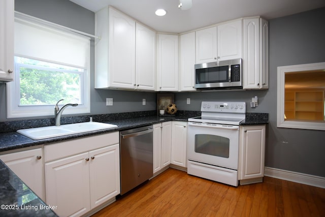 3521 Warner Ave, Louisville, KY 40207 - kitchen featuring appliances with stainless steel finishes, a sink, white cabinets, light wood finished floors, and recessed lighting