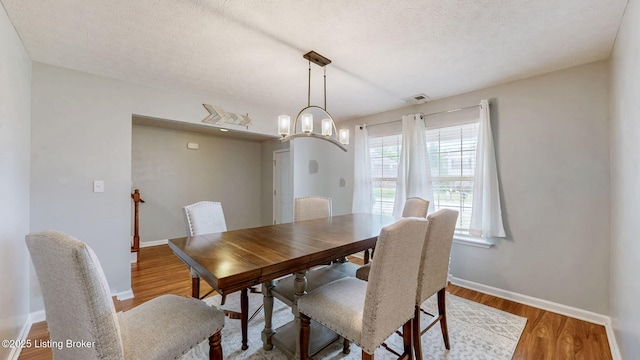 134 Wood Duck Ct, Shepherdsville, KY 40165 - dining area featuring baseboards, wood finished floors, a textured ceiling, and a chandelier