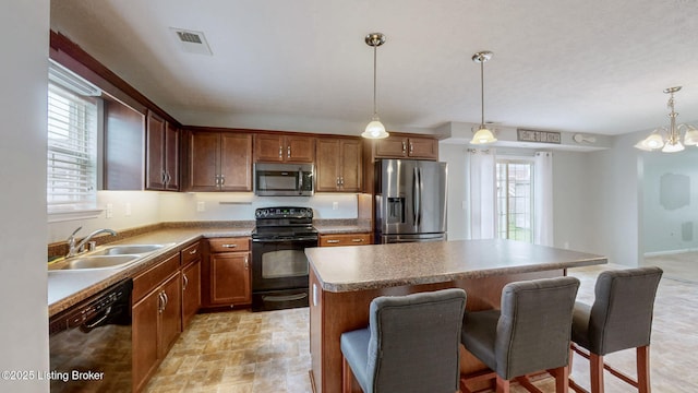 134 Wood Duck Ct, Shepherdsville, KY 40165 - kitchen featuring black appliances, a kitchen island, a breakfast bar, a sink, and hanging light fixtures