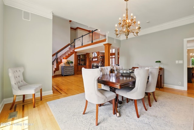 1014 Anchorage Woods Cir, Anchorage, KY 40223 - dining space featuring a chandelier, wood finished floors, stairway, crown molding, and baseboards