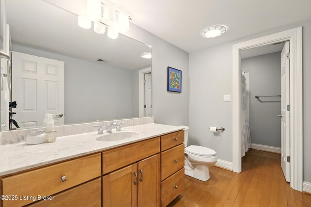 1014 Anchorage Woods Cir, Anchorage, KY 40223 - bathroom featuring wood-type flooring, toilet, vanity, baseboards, and a shower with curtain
