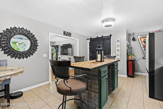 2327 Highgrove Rd, Coxs Creek, KY 40013 - kitchen with freestanding refrigerator, butcher block countertops, green cabinets, a barn door, and light tile patterned floors