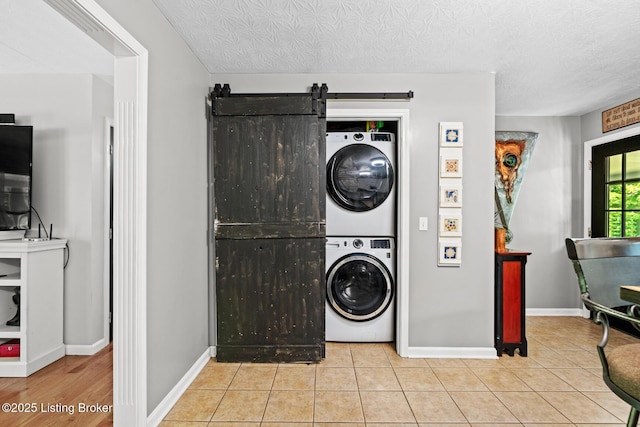 2327 Highgrove Rd, Coxs Creek, KY 40013 - washroom with stacked washer / dryer, a barn door, baseboards, tile patterned flooring, and a textured ceiling