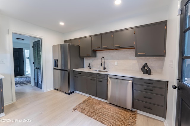508 Wilderness Rd, Louisville, KY 40214 - kitchen featuring appliances with stainless steel finishes, a sink, light wood finished floors, tasteful backsplash, and light countertops