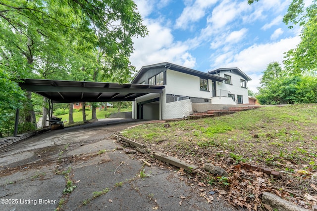 508 Wilderness Rd, Louisville, KY 40214 - view of home's exterior featuring driveway, brick siding, a carport, and an attached garage