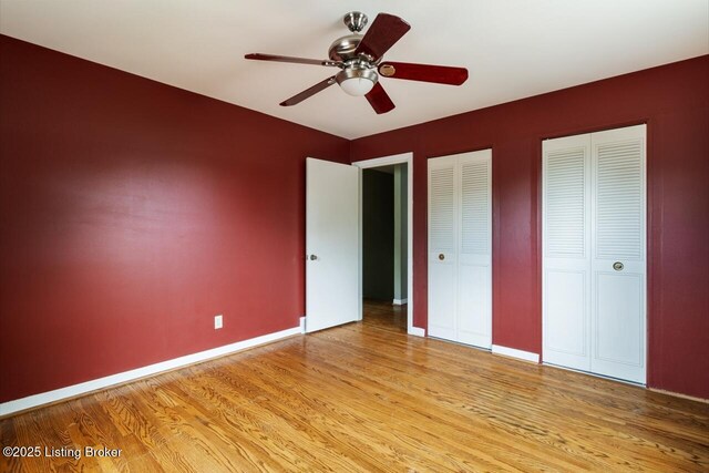 2603 Ballad Blvd, Jeffersontown, KY 40299 - unfurnished bedroom featuring two closets, light wood finished floors, baseboards, and ceiling fan