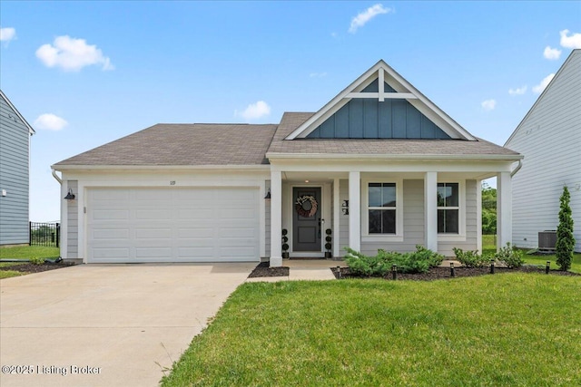 119 Wildflower Ave, Mt Washington, KY 40047 - view of front facade with board and batten siding, a front lawn, a garage, concrete driveway, and a porch