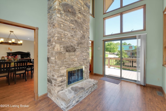 763 Lochober Rd, Leitchfield, KY 42754 - living room featuring a chandelier, a high ceiling, wood finished floors, a stone fireplace, and baseboards