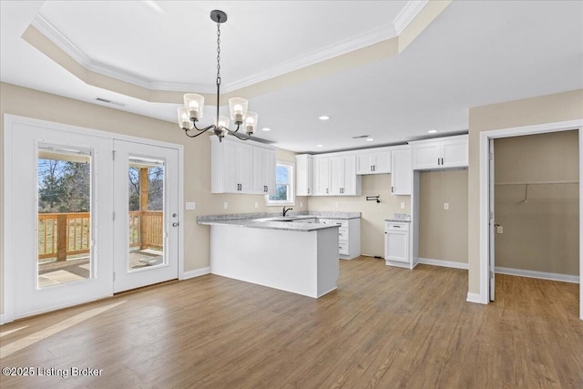 102 Kidd Ct, Lebanon Junction, KY 40150 - kitchen featuring a peninsula, ornamental molding, plenty of natural light, a chandelier, and wood finished floors