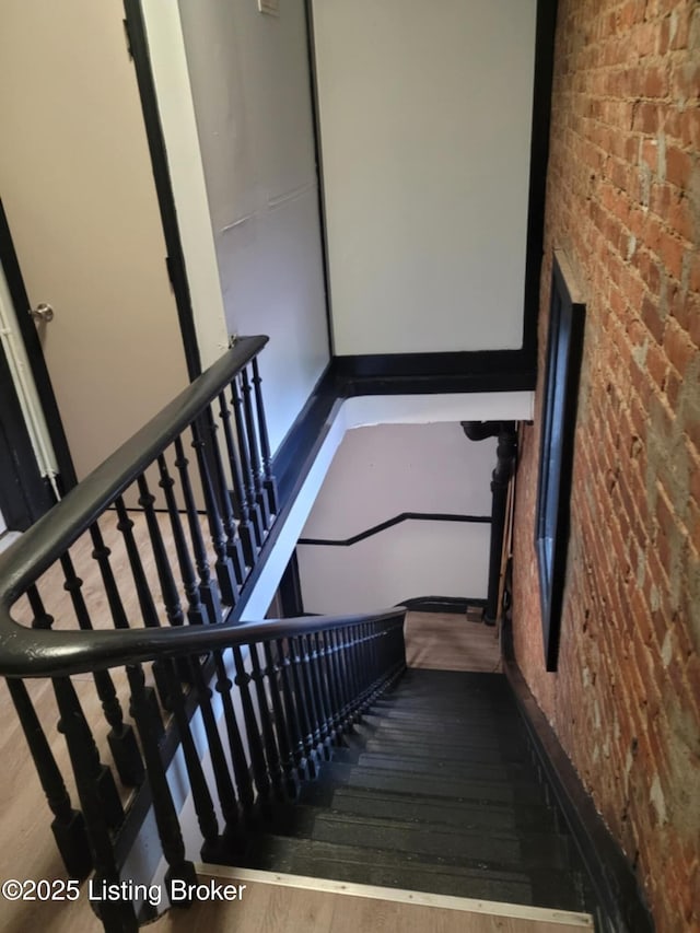 224 E Oak St, Louisville, KY 40203 - stairway featuring wood finished floors and brick wall