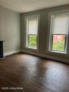 224 E Oak St, Louisville, KY 40203 - unfurnished living room featuring baseboards and wood finished floors