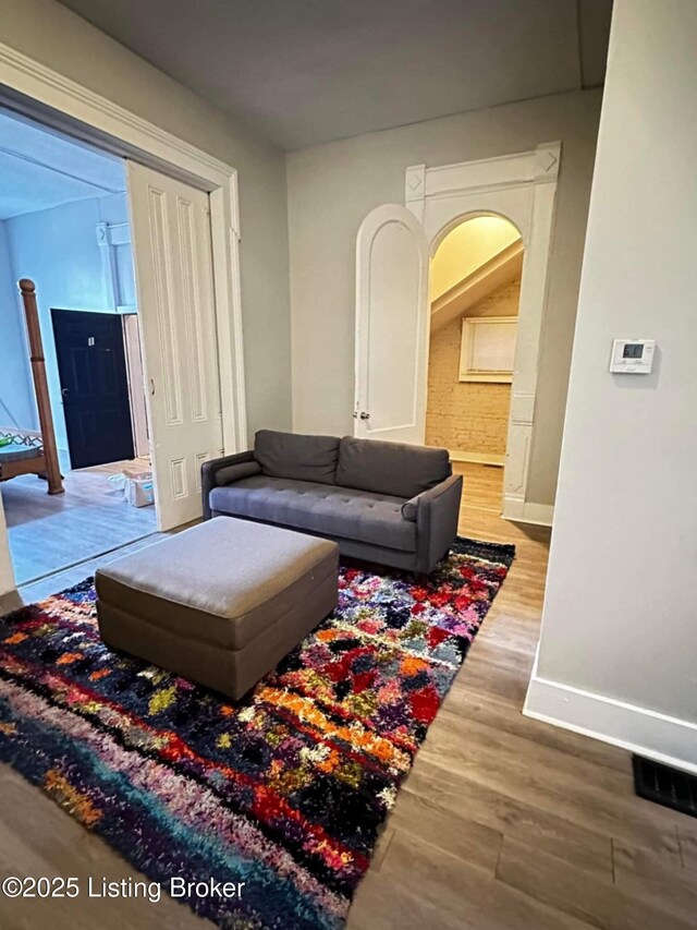 224 E Oak St, Louisville, KY 40203 - living area featuring arched walkways, baseboards, and wood finished floors