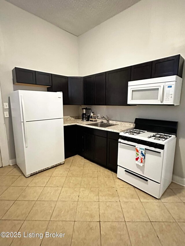 224 E Oak St, Louisville, KY 40203 - kitchen with white appliances, a sink, dark cabinetry, light countertops, and a textured ceiling