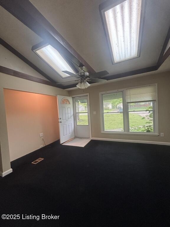 9304 New Maple Rd, Louisville, KY 40229 - empty room with vaulted ceiling, carpet floors, a skylight, and a ceiling fan