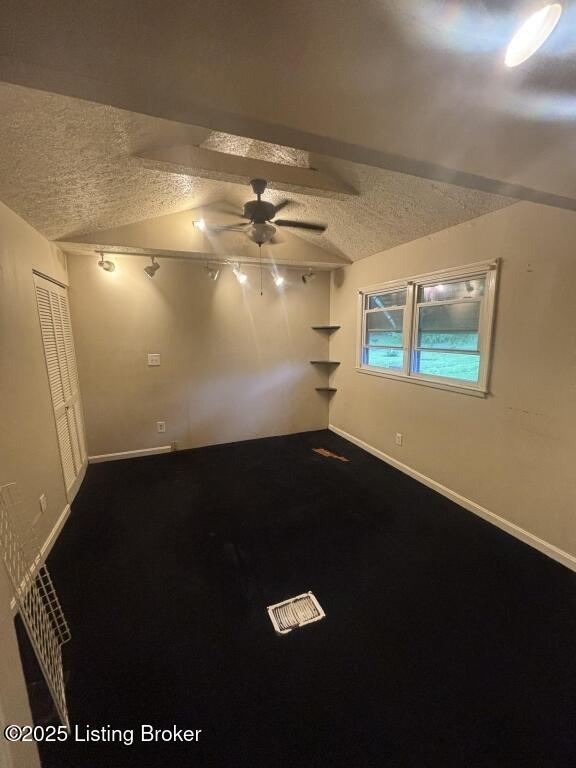 9304 New Maple Rd, Louisville, KY 40229 - unfurnished room with a textured ceiling, a ceiling fan, vaulted ceiling, and dark carpet