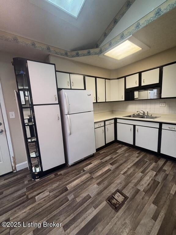 9304 New Maple Rd, Louisville, KY 40229 - kitchen with freestanding refrigerator, dark wood-style floors, white cabinetry, light countertops, and backsplash