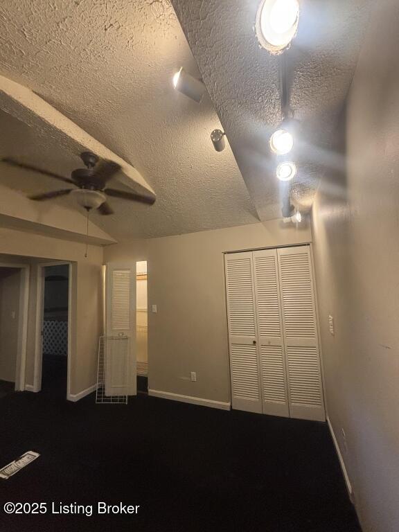 9304 New Maple Rd, Louisville, KY 40229 - unfurnished bedroom featuring a textured ceiling, a closet, dark colored carpet, and ceiling fan