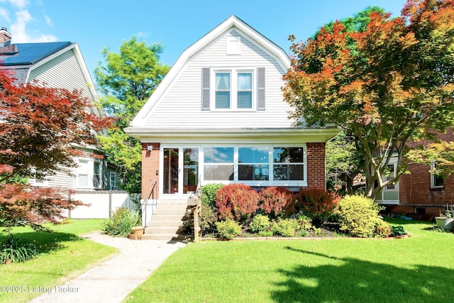 4714 Burkley Ave, Louisville, KY 40214 - colonial inspired home featuring a gambrel roof, a front lawn, entry steps, and brick siding