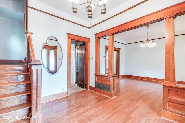 4714 Burkley Ave, Louisville, KY 40214 - empty room featuring ornate columns, a chandelier, light wood-style floors, stairs, and baseboards