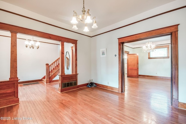 4714 Burkley Ave, Louisville, KY 40214 - unfurnished room featuring a chandelier, light wood finished floors, stairway, baseboards, and crown molding