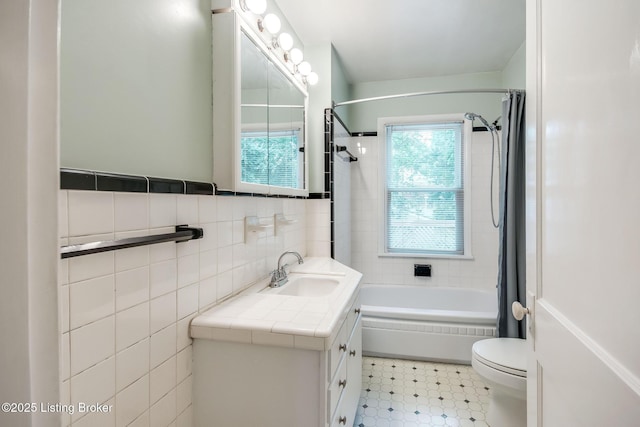 4714 Burkley Ave, Louisville, KY 40214 - full bathroom featuring vanity, shower / bath combo, toilet, tile walls, and tile patterned floors