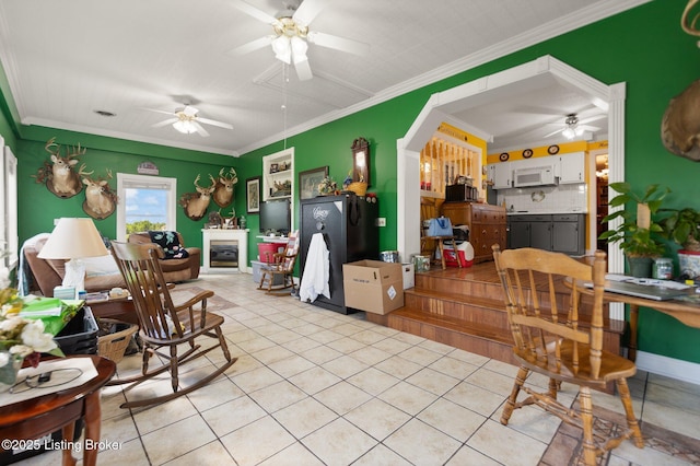 13429 Anneta Rd, Leitchfield, KY 42754 - living area with a ceiling fan, light tile patterned flooring, a glass covered fireplace, arched walkways, and crown molding