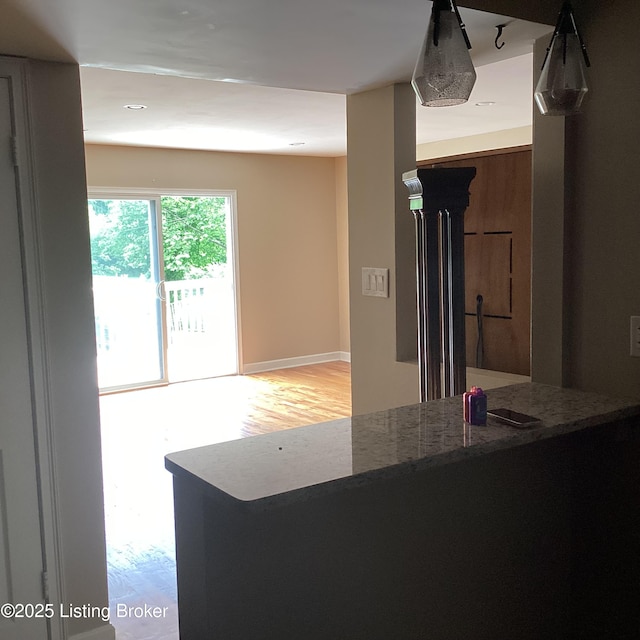 1815 Gardiner Ln Unit A9, Louisville, KY 40205 - kitchen with light wood-style floors, stone countertops, and baseboards