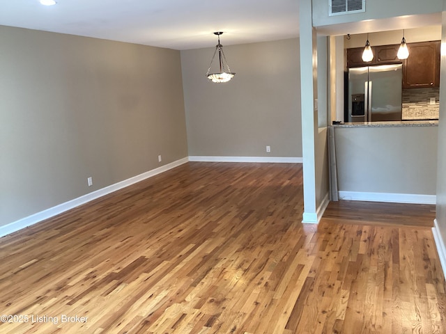 1815 Gardiner Ln Unit A9, Louisville, KY 40205 - kitchen featuring stainless steel fridge, wood finished floors, a chandelier, decorative light fixtures, and backsplash