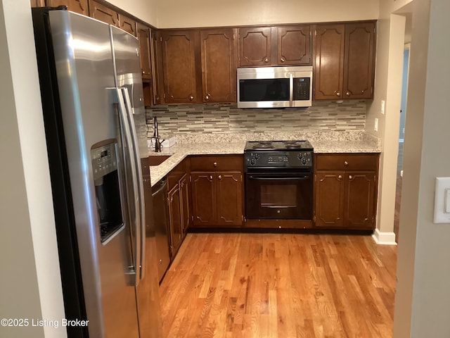 1815 Gardiner Ln Unit A9, Louisville, KY 40205 - kitchen with stainless steel appliances, light wood-style flooring, backsplash, and dark brown cabinetry