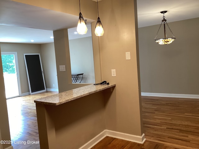 1815 Gardiner Ln Unit A9, Louisville, KY 40205 - kitchen with wood finished floors, light stone countertops, a peninsula, hanging light fixtures, and recessed lighting