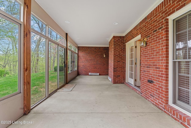 10121 Cave Creek Rd, Louisville, KY 40223 - unfurnished sunroom featuring crown molding, brick wall, and concrete flooring