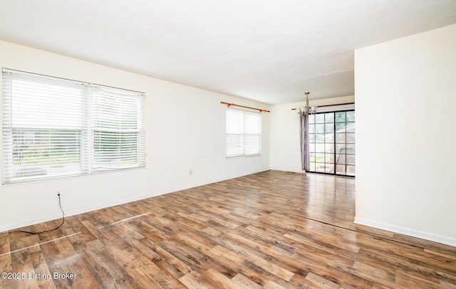 112 Bivins Ct, Radcliff, KY 40160 - empty room with wood finished floors, baseboards, and a chandelier