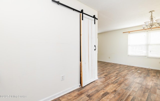 112 Bivins Ct, Radcliff, KY 40160 - empty room with a barn door, a chandelier, wood finished floors, and baseboards