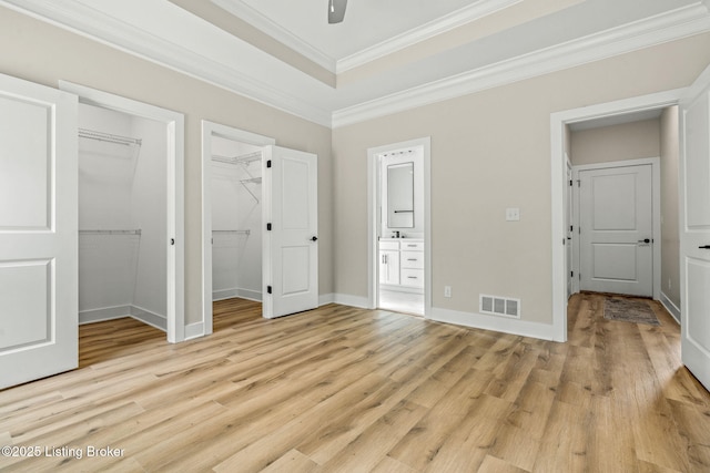 5311 Lee Ave, Crestwood, KY 40014 - unfurnished bedroom featuring crown molding, light wood finished floors, a walk in closet, connected bathroom, and baseboards