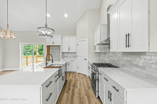 5311 Lee Ave, Crestwood, KY 40014 - kitchen featuring stainless steel range with gas stovetop, a chandelier, wall chimney exhaust hood, white cabinetry, and lofted ceiling