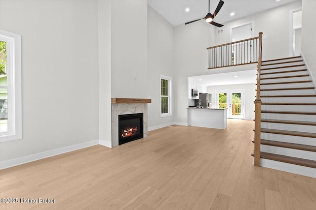 6702 Shirley Ave, Louisville, KY 40059 - unfurnished living room featuring a ceiling fan, light wood finished floors, a fireplace, a towering ceiling, and recessed lighting