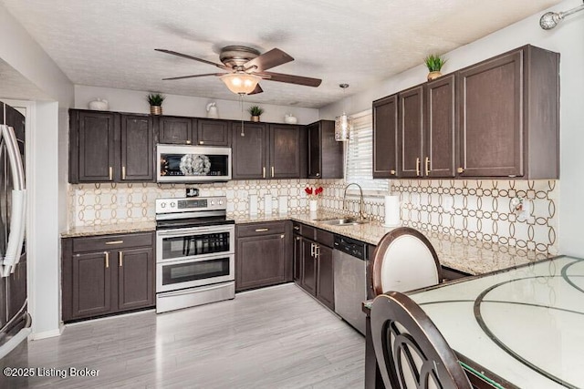 9505 River Trail Dr, Louisville, KY 40229 - kitchen featuring stainless steel appliances, a sink, dark brown cabinets, and a ceiling fan
