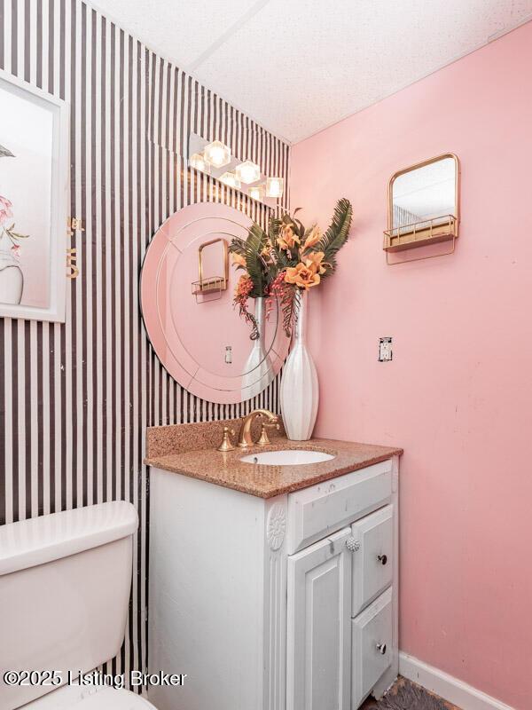 9505 River Trail Dr, Louisville, KY 40229 - half bathroom featuring vanity, toilet, baseboards, and wallpapered walls