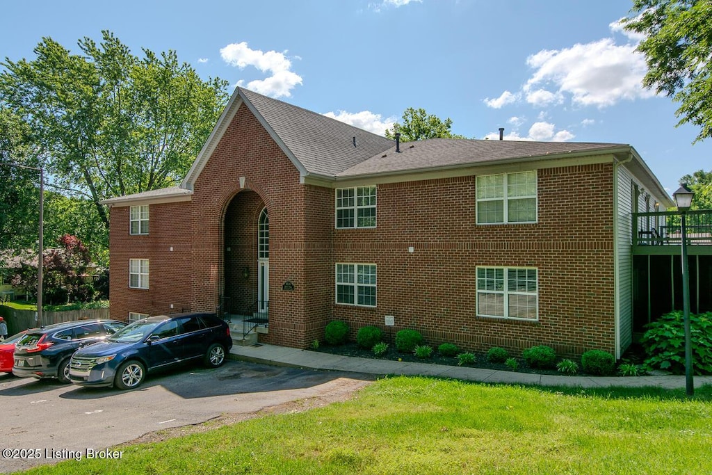 1038 Brent St Unit 200, Louisville, KY 40204 - view of front of home with brick siding, a shingled roof, and a front lawn