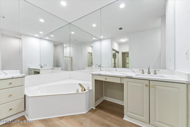 3447 Hurstbourne Ridge Blvd, Louisville, KY 40299 - bathroom with wood finished floors, a garden tub, vanity, and recessed lighting